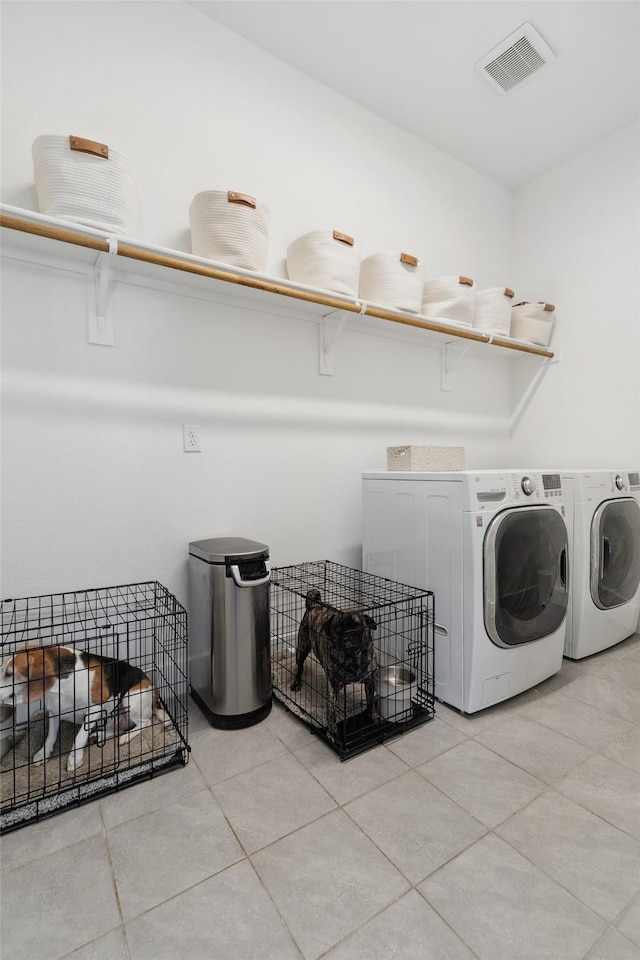 laundry area with light tile patterned floors, visible vents, separate washer and dryer, and laundry area