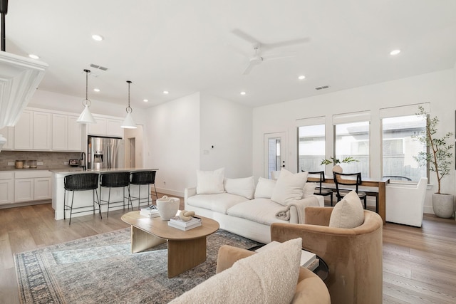 living room featuring recessed lighting, visible vents, a ceiling fan, and light wood finished floors