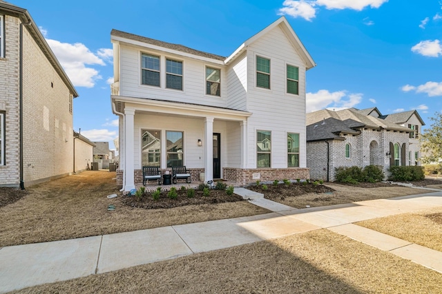 view of front of home featuring brick siding and covered porch