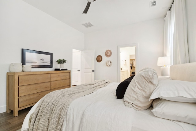 bedroom featuring ensuite bath, a ceiling fan, visible vents, and dark wood-style flooring