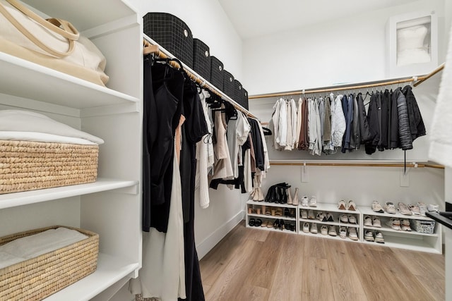 walk in closet with wood finished floors