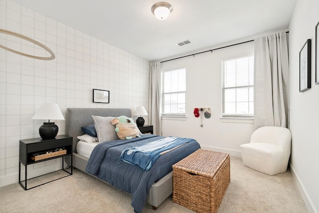 carpeted bedroom featuring visible vents, baseboards, and tile walls