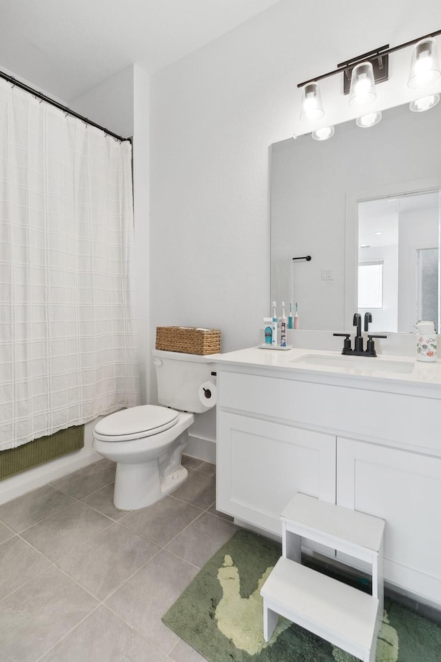 bathroom with a shower with curtain, toilet, vanity, and tile patterned flooring