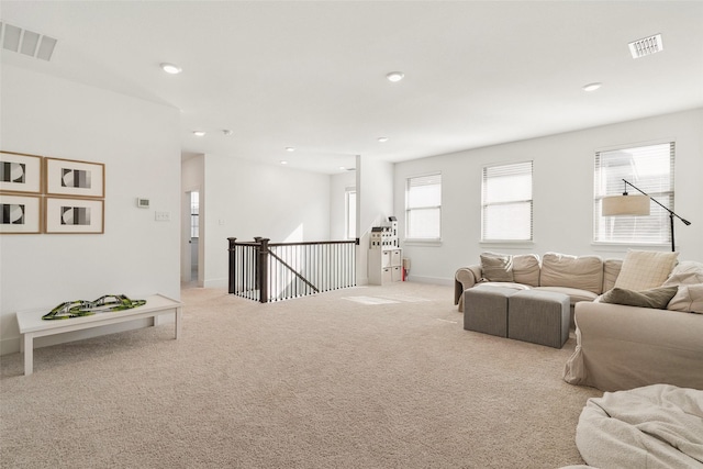 living room with recessed lighting, visible vents, and carpet flooring