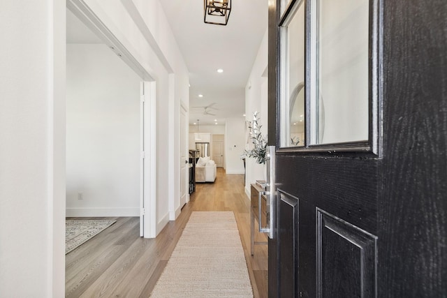 corridor with recessed lighting, light wood-type flooring, and baseboards