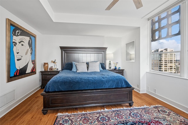 bedroom featuring visible vents, baseboards, and wood finished floors