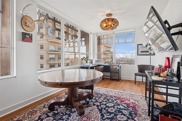 dining space featuring an inviting chandelier, baseboards, and wood finished floors