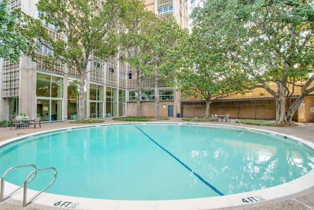 pool with fence and a patio area