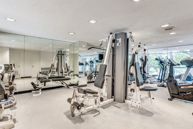 gym with a textured ceiling, visible vents, carpet floors, and recessed lighting