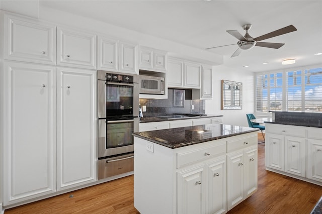 kitchen featuring a warming drawer, stainless steel appliances, light wood-style flooring, and a ceiling fan