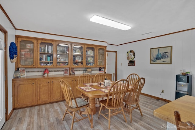 dining room with visible vents, light wood finished floors, and ornamental molding