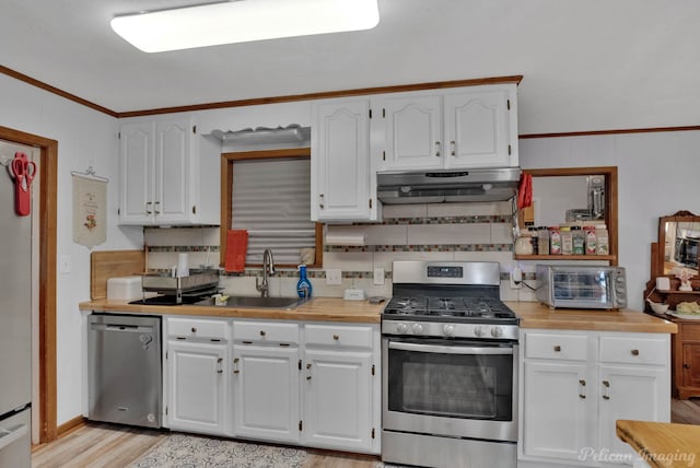 kitchen featuring under cabinet range hood, a sink, appliances with stainless steel finishes, white cabinets, and a toaster