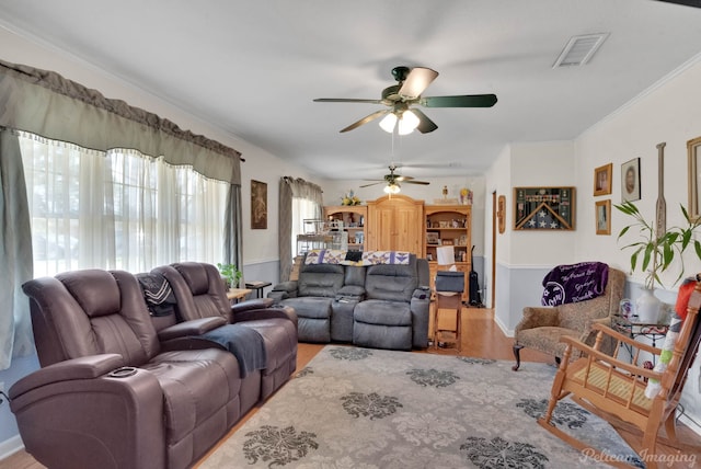 living room featuring visible vents, wood finished floors, ornamental molding, and a ceiling fan