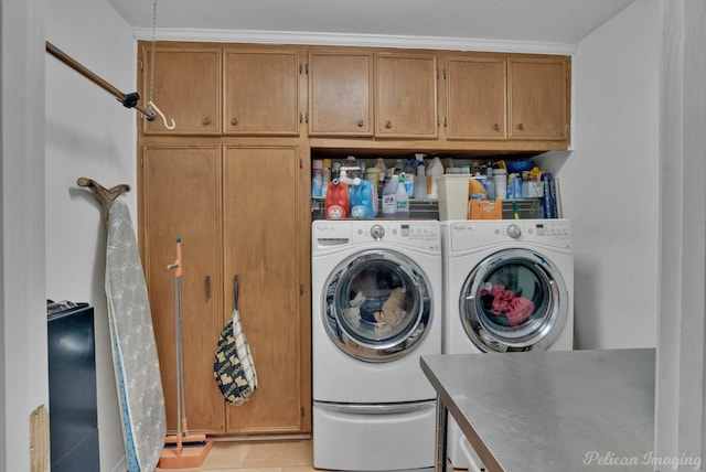 laundry room with light tile patterned floors, cabinet space, and washing machine and clothes dryer