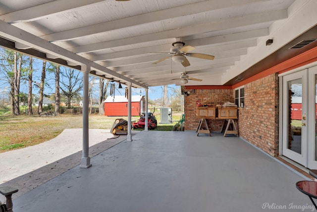 view of patio / terrace with an outbuilding, central AC unit, visible vents, ceiling fan, and a storage shed