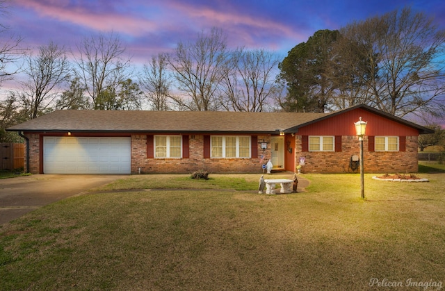 ranch-style house with a yard, concrete driveway, a garage, and brick siding