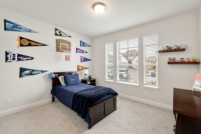 bedroom with baseboards and light carpet