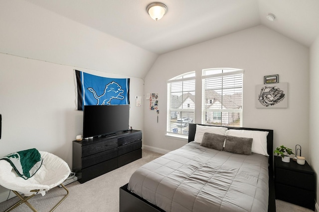 carpeted bedroom with lofted ceiling and baseboards