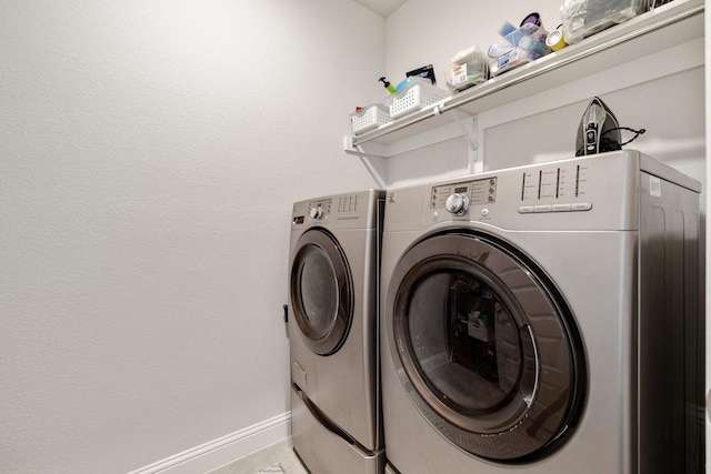 laundry room featuring laundry area, baseboards, and washing machine and clothes dryer