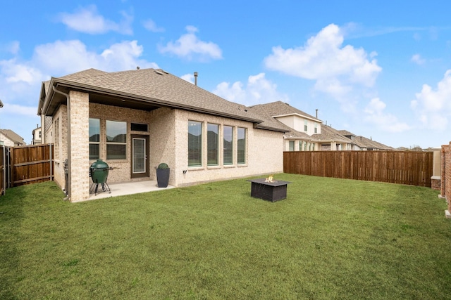 rear view of house featuring a yard, a patio, roof with shingles, and a fenced backyard