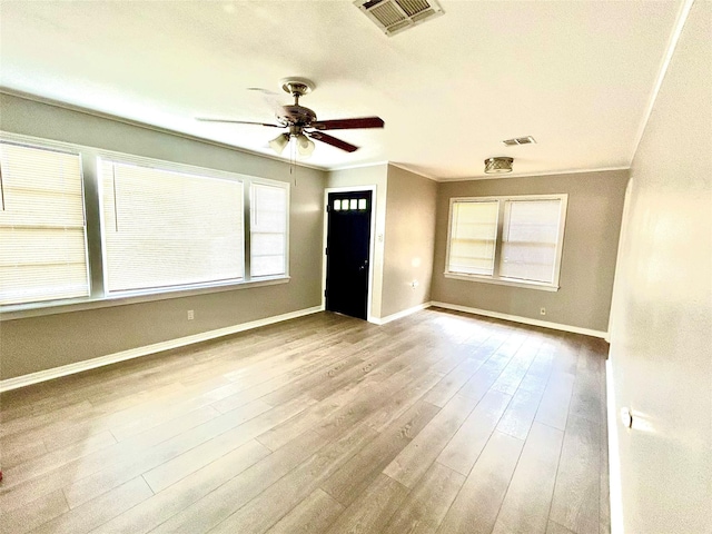 spare room with visible vents, a healthy amount of sunlight, ceiling fan, and wood finished floors