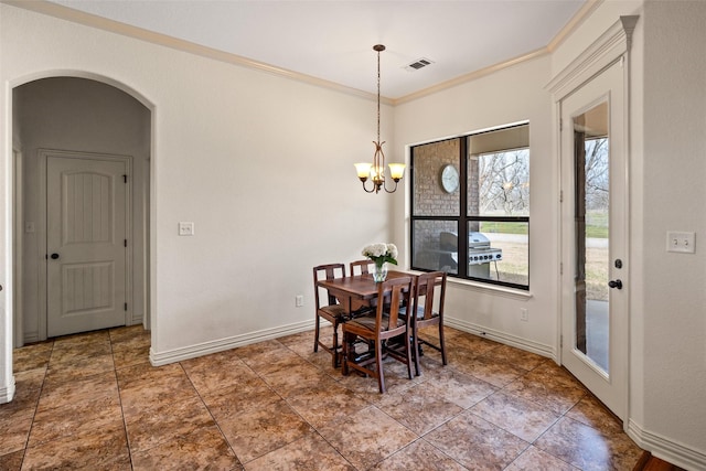 dining room with arched walkways, visible vents, baseboards, and ornamental molding