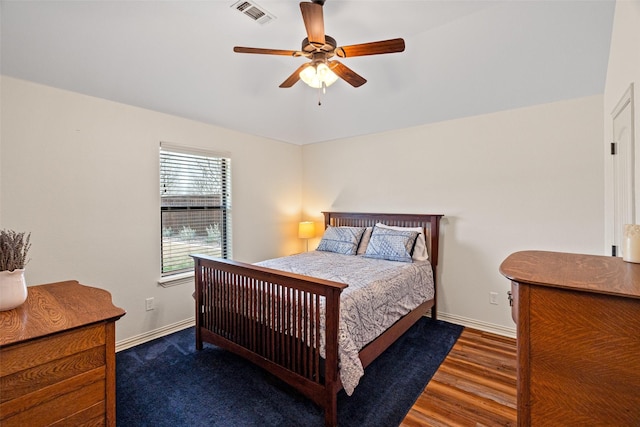 bedroom featuring visible vents, wood finished floors, baseboards, and vaulted ceiling