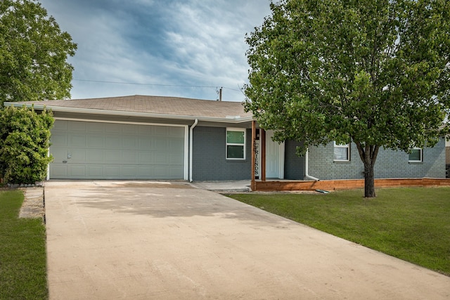 view of front of house featuring a garage, driveway, brick siding, and a front lawn