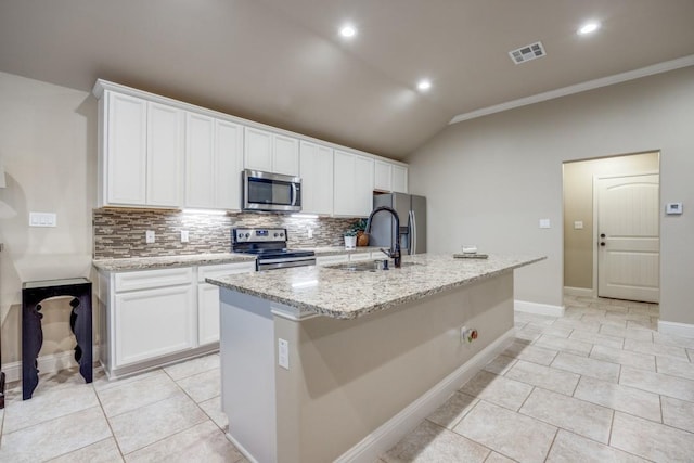 kitchen featuring visible vents, appliances with stainless steel finishes, an island with sink, and decorative backsplash