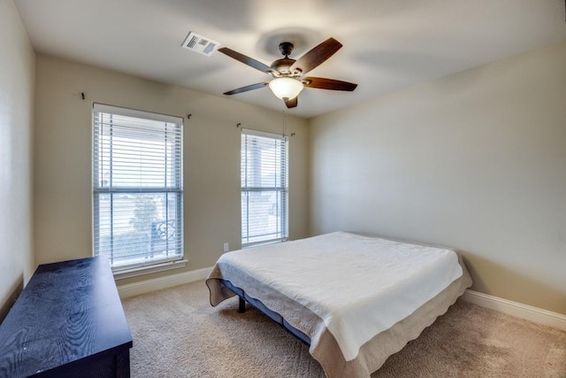 carpeted bedroom featuring visible vents, ceiling fan, and baseboards