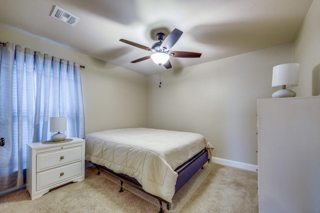 bedroom with visible vents, baseboards, light colored carpet, and a ceiling fan