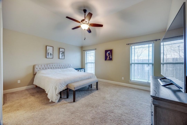 carpeted bedroom featuring baseboards, multiple windows, and a ceiling fan