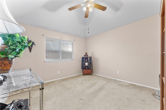 interior space with lofted ceiling, a ceiling fan, baseboards, and carpet floors