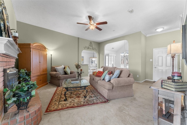 living area with light carpet, a brick fireplace, a ceiling fan, and arched walkways