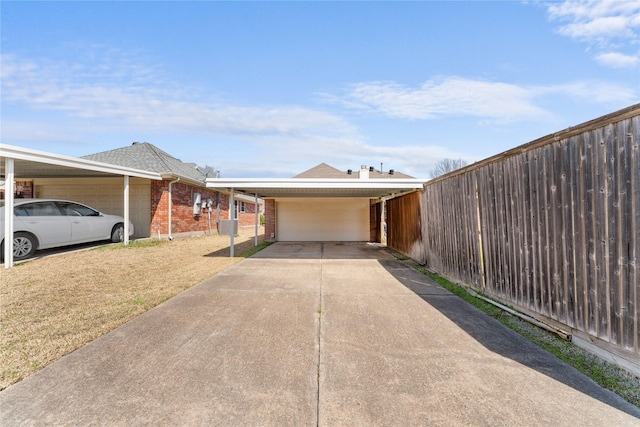 view of front of property featuring fence, a carport, concrete driveway, a front lawn, and brick siding