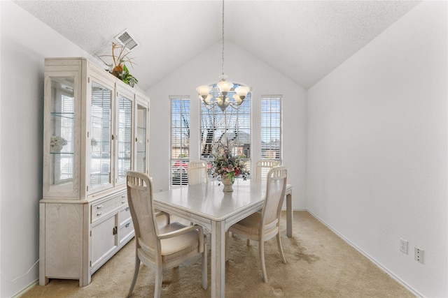 dining area featuring visible vents, a chandelier, light colored carpet, lofted ceiling, and a textured ceiling