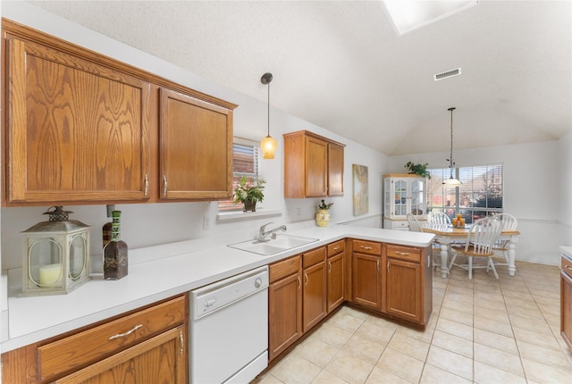 kitchen with visible vents, brown cabinets, a sink, light countertops, and dishwasher