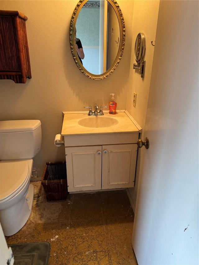 bathroom with vanity, toilet, and baseboards