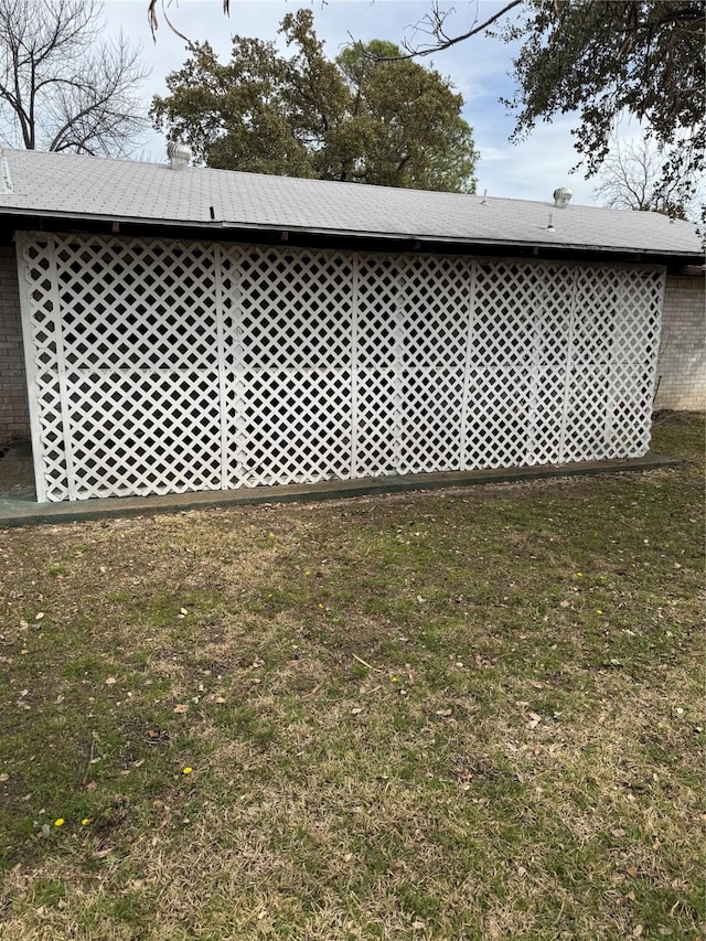 view of side of home featuring a lawn and brick siding