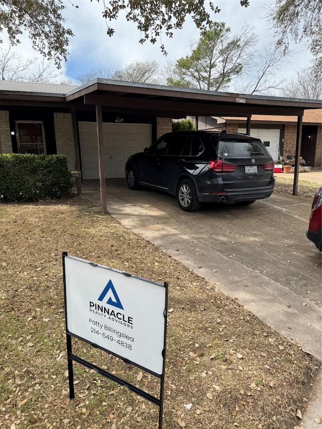 view of car parking with a carport, concrete driveway, and a garage