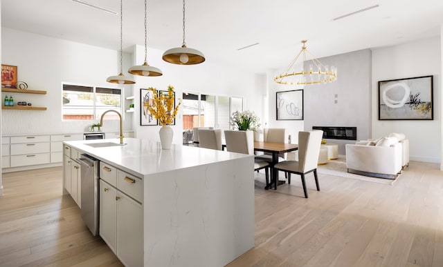 kitchen featuring open shelves, light wood-style flooring, plenty of natural light, a sink, and a chandelier