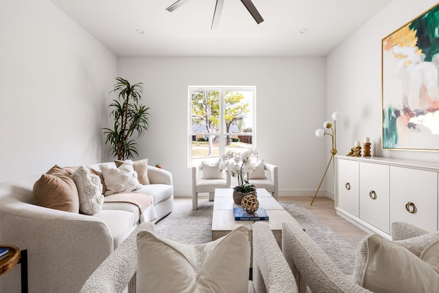 living area featuring light wood-style flooring, baseboards, and ceiling fan