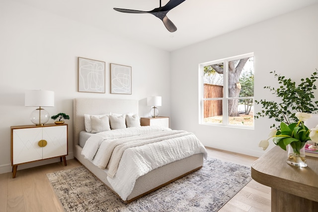 bedroom featuring ceiling fan, baseboards, and light wood-style flooring