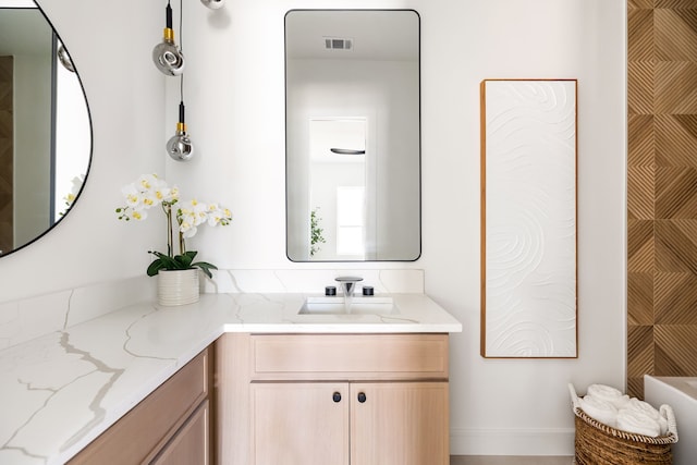 full bathroom featuring visible vents, a bath, and vanity