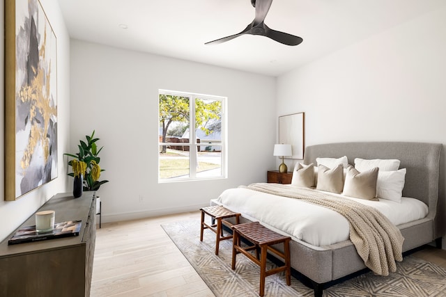 bedroom with baseboards, light wood-type flooring, and ceiling fan