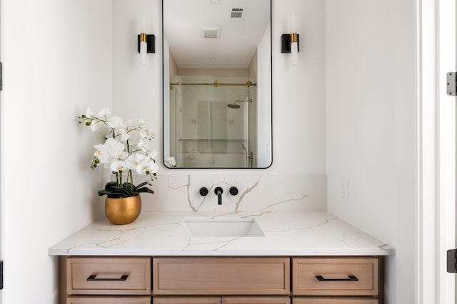 bathroom with vanity, a shower stall, and visible vents