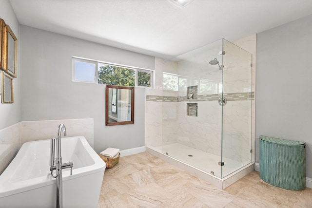 full bathroom featuring a freestanding tub, baseboards, and a stall shower