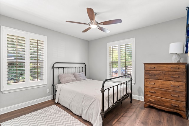 bedroom with a ceiling fan, wood finished floors, and baseboards