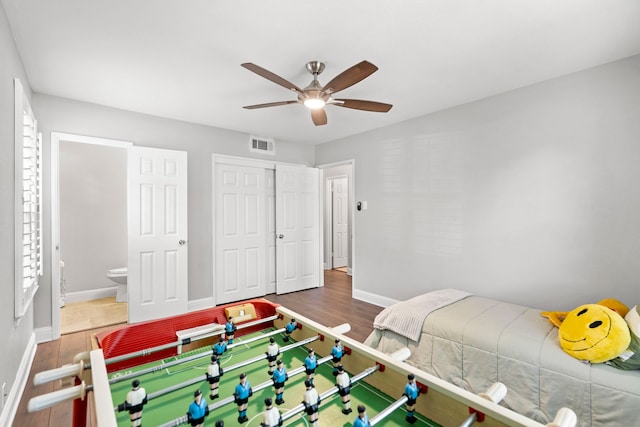 bedroom featuring a closet, visible vents, baseboards, and wood finished floors