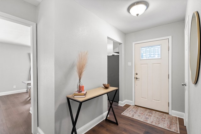 entryway with dark wood finished floors and baseboards